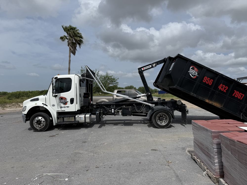 Rockin JL roll off truck setting a dumpster at a jobsite